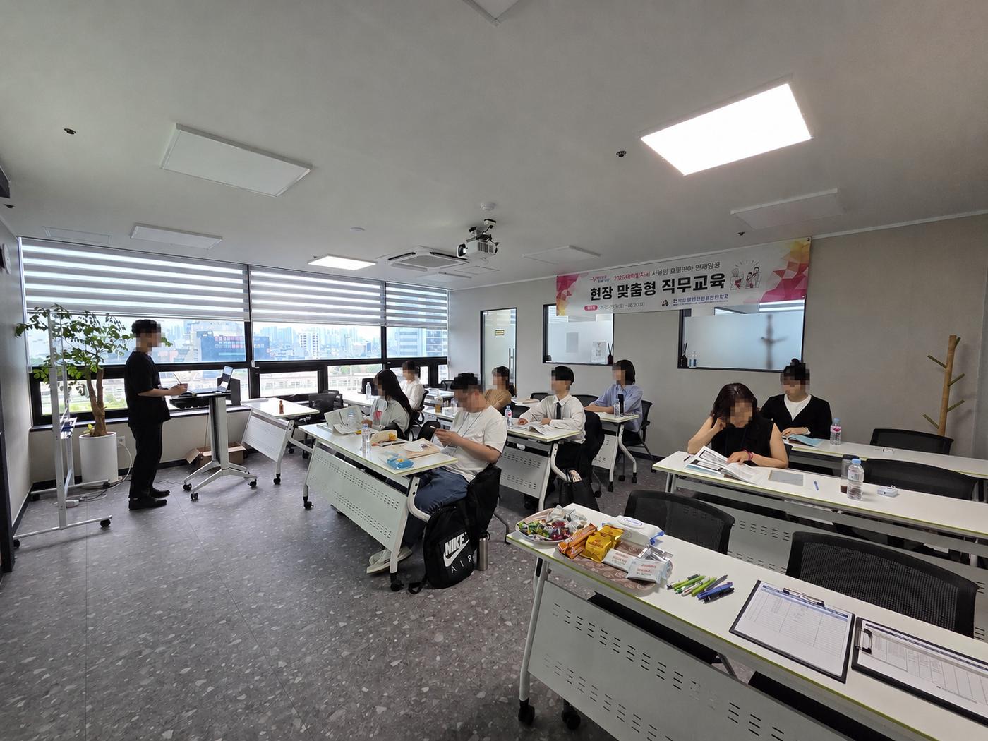 이전 기업 출강에서 강사가 설명하고 수강생이 자리에 앉아 듣는 모습